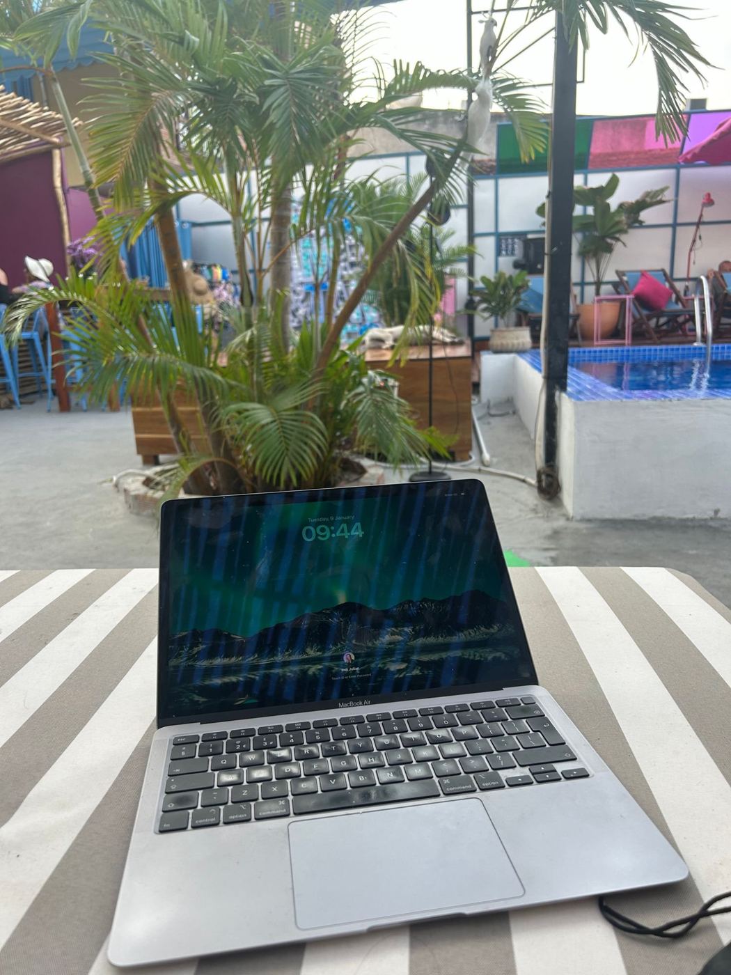A laptop open by the pool, lesson prep in the sunshine